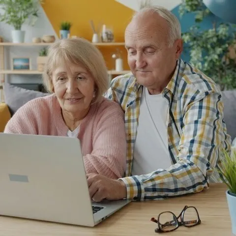 Oud stel achter laptop